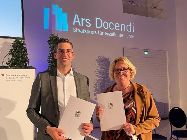 Zwei Menschen mit Auszeichnung in den Händen, dahinter Schriftzug "Ars Docendi"